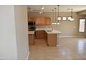 Bright kitchen featuring wood cabinets, stainless steel appliances, and a large kitchen island at 6460 S Springs Pl, Chandler, AZ 85249