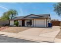 Cozy home featuring a well-kept yard, desert landscaping, and a convenient two-car garage at 733 E Halifax St, Mesa, AZ 85203