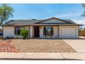 Charming single-level home featuring a low-maintenance desert landscape and a two-car garage at 733 E Halifax St, Mesa, AZ 85203