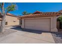 Single Gathering house featuring two car garage, desert landscaping, and red tiled roof at 7531 W Kimberly Way, Glendale, AZ 85308