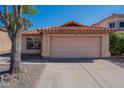 Single Gathering house featuring two car garage, desert landscaping, and red tiled roof at 7531 W Kimberly Way, Glendale, AZ 85308