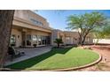 Spacious backyard featuring lush artificial turf, a cozy patio, and desert landscaping at 8540 E Mcdowell Rd # 116, Mesa, AZ 85207