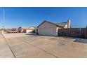 View of the two-car garage, concrete driveway, and fenced yard for added privacy and security at 9009 W Butler Dr, Peoria, AZ 85345