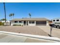 Charming single-story white home with a gravel yard, and a black mailbox and garage door at 9214 N 54Th Ave, Glendale, AZ 85302