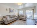 Cozy living room with comfortable sofas, neutral tones, and sliding glass door to outside at 941 E Desert Moon Trl, San Tan Valley, AZ 85143