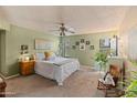 Bright main bedroom featuring carpeted floors, a ceiling fan, and a window with natural light at 14420 N 44Th Dr, Glendale, AZ 85306