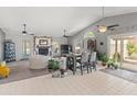 Spacious living room with a fireplace, vaulted ceilings, tile floors, and sliding glass doors to the patio at 14420 N 44Th Dr, Glendale, AZ 85306