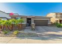 Charming single-story home featuring a well-kept yard with small palm trees, brick accents, and a two-car garage at 17866 W Lilac St, Goodyear, AZ 85338