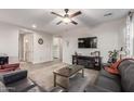 Spacious living room with comfortable leather seating, modern ceiling fan, and large television at 17866 W Lilac St, Goodyear, AZ 85338