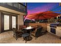 Relaxing outdoor patio with fire pit, seating, built-in grill, and desert views for cozy evenings at 17903 N 93Rd Way, Scottsdale, AZ 85255