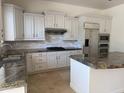 Well-appointed kitchen featuring stainless steel appliances, granite countertops, and white cabinets at 22903 N 39Th Ter, Phoenix, AZ 85050