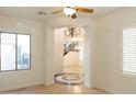 Bright living room featuring tile floors, a decorative medallion, and an archway leading to stairs and another room at 22903 N 39Th Ter, Phoenix, AZ 85050