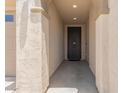 Inviting front entrance with stucco walls, lights, and a dark-colored door at 22920 E Indiana Ave, Queen Creek, AZ 85142