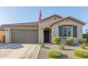 Inviting front exterior with tidy landscaping, a two-car garage, and a traditional design at 22920 E Indiana Ave, Queen Creek, AZ 85142