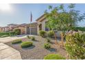 Well-maintained front yard with desert landscaping and a view of the charming home at 22920 E Indiana Ave, Queen Creek, AZ 85142