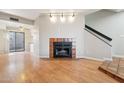 Open-concept living area with fireplace, wood floors, and a slider to the patio at 2815 N 52Nd St # 3, Phoenix, AZ 85008