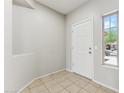 Bright entryway features neutral tile flooring, a white front door, and a window showcasing the exterior at 3310 W Chambers St, Phoenix, AZ 85041