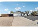 Charming single-story home with a two-car garage and a spacious driveway leading to a side gate at 3410 E Everett Dr, Phoenix, AZ 85032