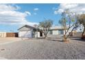 Charming single-story home featuring gravel landscaping with mature shade trees in the front yard at 3410 E Everett Dr, Phoenix, AZ 85032