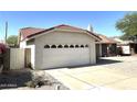 Home featuring a two-car garage with decorative trim and a red tile roof at 4008 E Knox Rd, Phoenix, AZ 85044