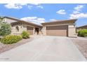 Charming home featuring a three-car garage, desert landscaping, and a welcoming red front door at 42726 N Livingstone Way, Anthem, AZ 85086