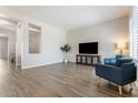 Bright living room featuring modern gray flooring, a TV, and comfortable blue armchairs at 42726 N Livingstone Way, Anthem, AZ 85086
