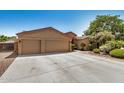 Wide driveway leading to a three-car garage, complemented by desert landscaping at 4345 E Annette Dr, Phoenix, AZ 85032