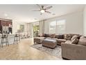 Bright living room featuring a large sectional sofa, tile floors, and sliding glass doors at 4807 W St Anne Ave, Laveen, AZ 85339