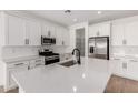 Bright kitchen featuring white cabinets, stainless steel appliances, quartz countertops and a pantry at 5023 W Hardtack Trl, Laveen, AZ 85339