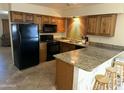Traditional kitchen offers wood cabinets, granite countertops, and a breakfast bar with seating at 564 N Santa Anna St, Mesa, AZ 85201