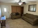 Cozy living room featuring neutral colors, tile flooring, and classic ceiling fan at 564 N Santa Anna St, Mesa, AZ 85201