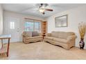 Bright living room featuring tile floors, a ceiling fan, and a comfortable seating area at 564 N Santa Anna St, Mesa, AZ 85201