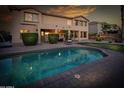 Tranquil backyard with a shimmering pool, covered patio, and ample green space for outdoor enjoyment at 7156 S Forest Ave, Gilbert, AZ 85298
