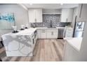 Modern kitchen with marble countertops, white cabinets, and stainless steel appliances at 7840 N 7Th St # 15, Phoenix, AZ 85020