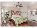 Well-lit bedroom with a decorative headboard, ceiling fan, and beautiful flooring at 925 W Hudson Way, Gilbert, AZ 85233