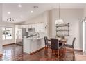 Open-concept kitchen featuring a breakfast bar, white cabinets, and stainless steel appliances at 925 W Hudson Way, Gilbert, AZ 85233