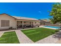 Beautiful backyard with lush green lawn, covered patio, and refreshing swimming pool, perfect for outdoor enjoyment at 10852 E Contessa St, Mesa, AZ 85207