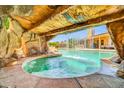 Unique view from inside the pool grotto, looking out at the waterfall and backyard at 10943 W Alice Ave, Peoria, AZ 85345