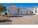 Spacious three-car garage with modern doors and stylish exterior lighting, complementing the home's architecture at 11250 W Prospector Dr, Queen Creek, AZ 85144