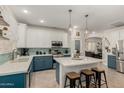 Bright eat-in kitchen featuring a center island, breakfast bar, blue cabinets, and pendant lighting at 12062 W Duane Ln, Peoria, AZ 85383