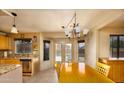 Bright eat-in kitchen area featuring a wooden table, chandelier, and door leading to the pool at 12933 W Monterey Way, Avondale, AZ 85392