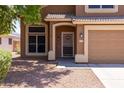 Inviting home exterior featuring a secure screen door, desert landscaping, and a warm, neutral color palette at 12933 W Monterey Way, Avondale, AZ 85392