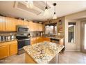 Kitchen with a granite island and countertops, stainless steel appliances, and wooden cabinetry at 12933 W Monterey Way, Avondale, AZ 85392
