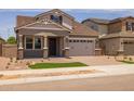 Charming home exterior featuring a front porch, a two-car garage, and neat landscaping at 15634 W Georgia Dr, Surprise, AZ 85379
