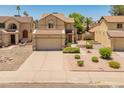 Exterior view of a charming two-story home with a two-car garage, low maintenance landscaping, and a desert-style front yard at 1606 N Apache Dr, Chandler, AZ 85244