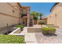Beautifully landscaped front yard featuring a desert-style design with cacti, bushes, and a two-story home in the background at 1606 N Apache Dr, Chandler, AZ 85244