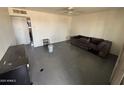 The living room has painted concrete floors and a ceiling fan at 2007 W Roeser Rd, Phoenix, AZ 85041