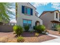 Beautiful two-story home with a light-colored exterior, blue shutters, and well-maintained front yard landscaping at 2494 N Heritage St, Buckeye, AZ 85396