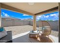Relaxing covered patio with comfortable seating and a spacious backyard featuring low-maintenance desert landscaping at 25657 W Beth Dr, Buckeye, AZ 85326