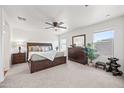 Spacious primary bedroom featuring a ceiling fan, plush carpet, and windows for natural light at 25657 W Beth Dr, Buckeye, AZ 85326